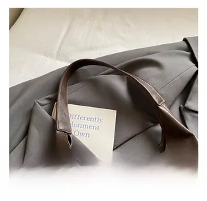 Close-up of durable brown leather tote handle stitching and premium refined texture