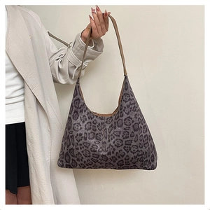 Detail of hobo tote bag featuring leopard print pattern and brown leather shoulder strap