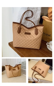 Detailed close-up of quilted tote bag with faux leather patch and sturdy handles