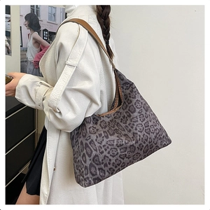 Side view of a vintage leopard print shoulder bag with brown leather straps for women