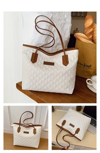 Detail of white quilted tote bag with brown leather handles and large interior capacity