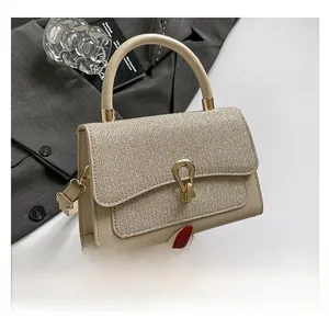 Detail of woven texture flap and golden horseshoe clasp on beige crossbody square bag