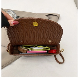Detail view of woven brown crossbody bag interior showing daily essentials storage