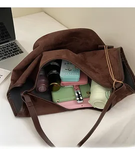 Top view of spacious dark brown suede tote bag interior with everyday essentials