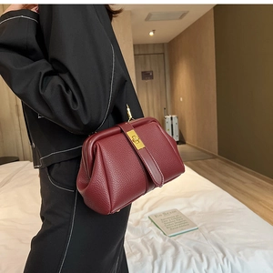 Close-up of wine red lychee grain leather doctor bag with golden metal rotary lock