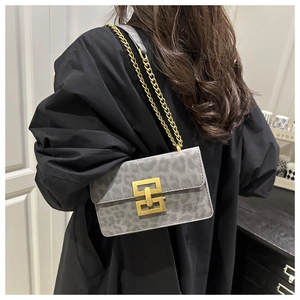 Detailed view of women's leopard print shoulder bag with gold chain and geometric clasp