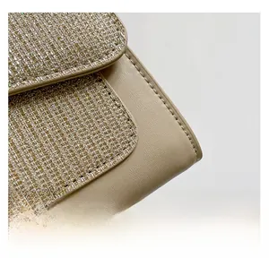 Close-up of beige tweed woven fabric with subtle sequins and neat leather stitching details