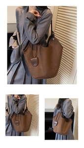 Detail of dark brown matte tote bag with thin shoulder strap and decorative pendant