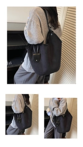 Close-up of black suede tote bag with slim leather straps and teardrop charm detail