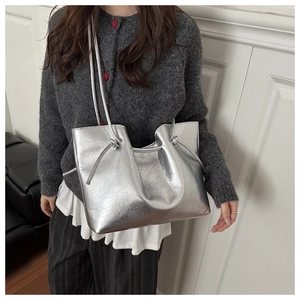Dettaglio della borsa tote argento metallizzato con tracolla annodata e texture