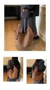 Macro detail of dark brown matte suede tote bag with smooth leather trim and stylish pendant