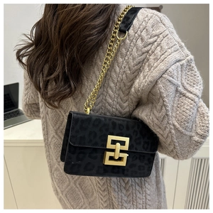 Detail of black leopard print suede crossbody bag with gold chain and metal buckle