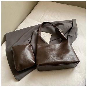 Close-up of vintage dark brown faux leather tote bag and matching inner pouch with texture