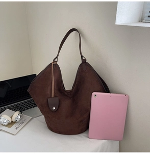 Grand sac cabas marron foncé en cuir mat comparé à un iPad pour montrer la capacité