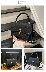 Detail of black glitter crossbody bag featuring a golden horseshoe twist lock and top handle