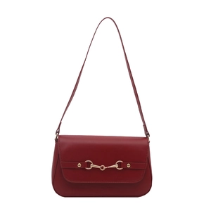 Deep red luxury minimalist shoulder bag with golden horsebit detail on a white background