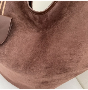 Vue détaillée du tissu en similicuir marron foncé et des finitions de ce sac cabas