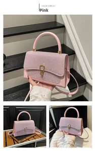Detail of pink rhinestone handbag with gold twist lock and adjustable shoulder strap