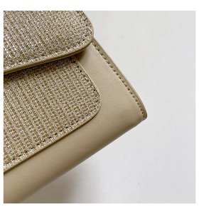 Detailed macro view of champagne gold sequins and beige faux leather stitching on handbag