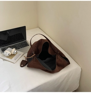 Détail d'un grand sac cabas vintage marron mat avec bandoulière dans un décor de bureau