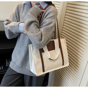 Detail of canvas tote bag with brown leather straps and Fashion & Bag printed text