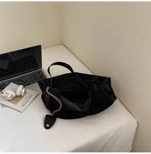 Vue de dessus d'un grand sac cabas noir sur un bureau avec ordinateur et casque
