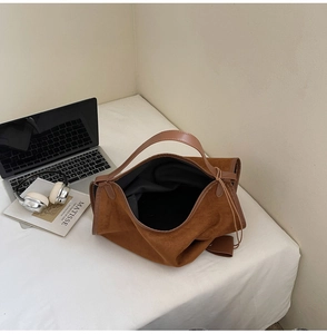 Détail d'un grand sac cabas marron en daim avec finitions en cuir et intérieur spacieux chic