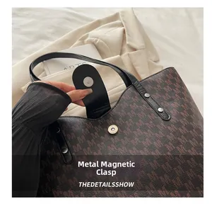 Detail of magnetic hardware closure on a large capacity monogram tote bag for work