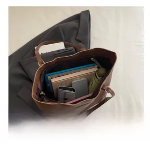 Intérieur spacieux du sac cabas vintage marron montrant le rangement pour tablette et objets