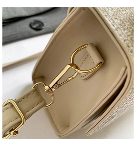 Detailed macro view of beige crossbody bag with sparkling rhinestones and gold hardware
