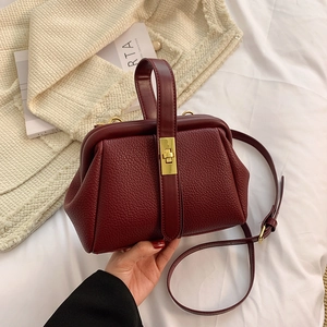 Elegant wine red pebbled leather satchel bag with gold hardware and top handle