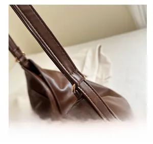 Detailed macro view of dark brown leather tote strap with precise stitching and gold rings