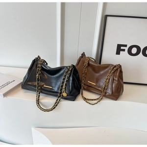 Detail of vintage tote bags in black and brown featuring elegant chain straps and gold accents