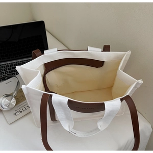 Spacious canvas tote bag with brown leather trim and inner zipper pocket for daily use