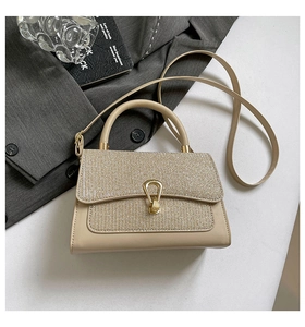 Detailed view of champagne glitter crossbody bag with elegant gold clasp and sleek handle