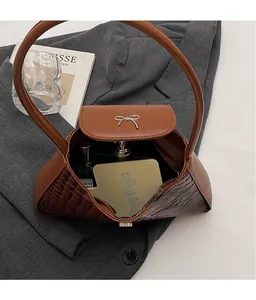 Detail view of the brown crocodile embossed bag interior with mirror and cosmetics