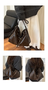 Detail of dark brown leather tote bag showing adjustable metal buckles and vintage texture