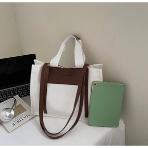 Detail of canvas tote bag with dual straps showing laptop and iPad storage capacity