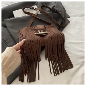 Detail of vintage brown suede crossbody bag featuring long fringe and silver buckle