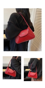 Detail of red crocodile texture handbag with metallic bow buckle and shiny leather finish