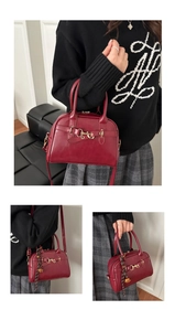 Close-up of wine red shell bag with gold hardware and woven pendant detail