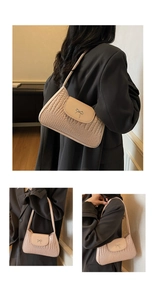 Detail of beige faux leather underarm bag with crocodile texture and silver metal bow
