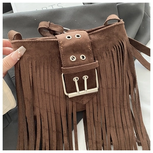Detail of dark brown suede shoulder bag with long fringes and metallic buckle design