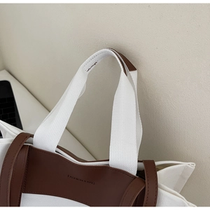 Close-up of canvas tote bag stitching with leather accents and Fashion & Bag lettering
