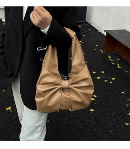 Détail du sac hobo kaki orné d'un nœud papillon décoratif et de cuir souple plissé élégant