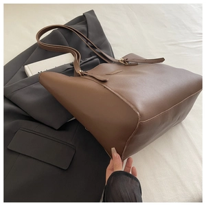 Vue détaillée du sac cabas en cuir marron avec boucle en métal et fine bandoulière