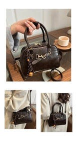 Detail of vintage brown Boston bag with golden horsebit and braided charm accessory