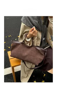 Outdoor shot of a vintage dark brown matte tote bag with leather handles on a bench
