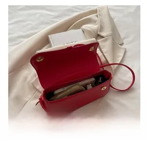 Vue intérieure de la capacité du sac à bandoulière en cuir rouge avec boucle magnétique