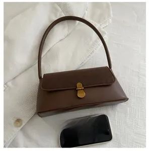 Detail of dark brown leather handbag showing vintage metal clasp and size comparison